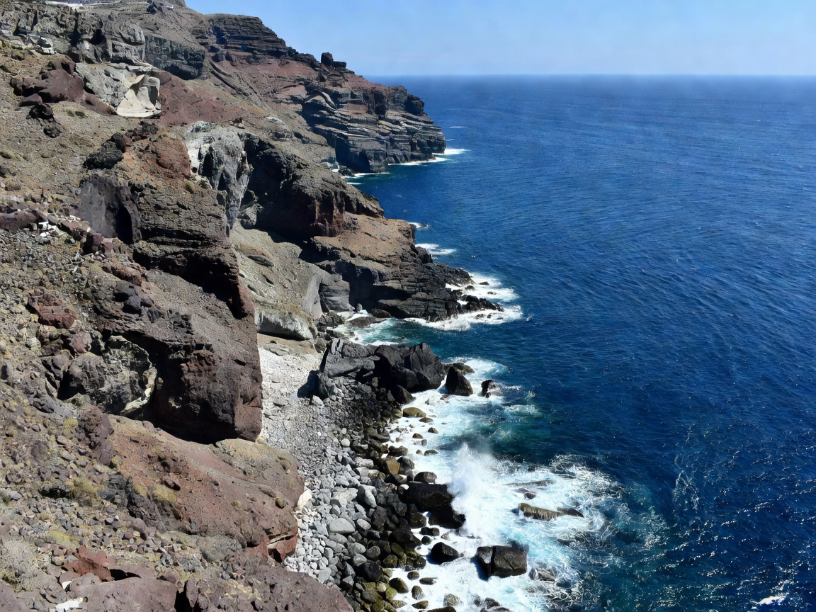 Rugged volcanic cliffs dropping into the deep blue Aegean sea in Santorini